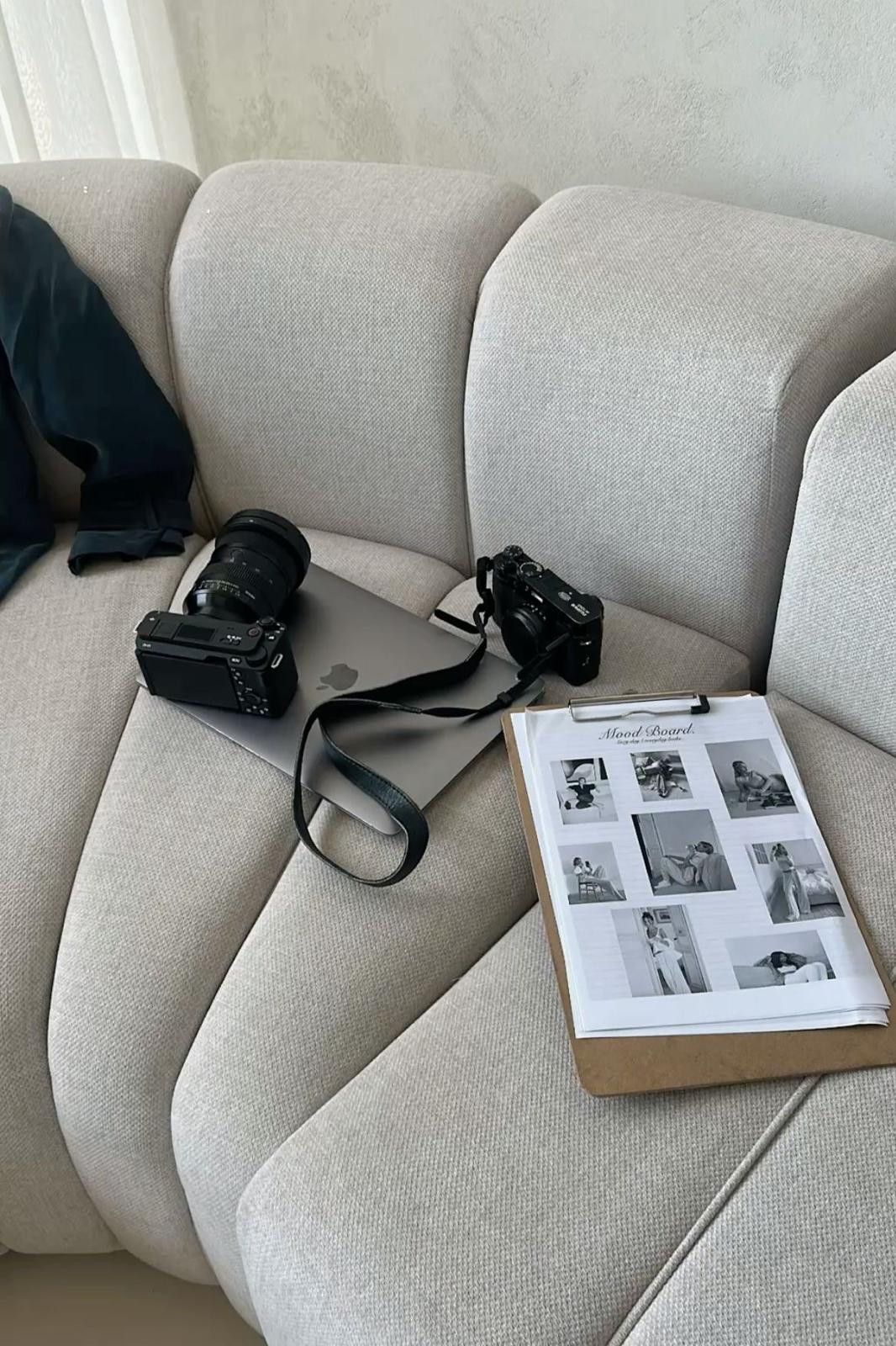 Camera equipment and a mood board on a sofa